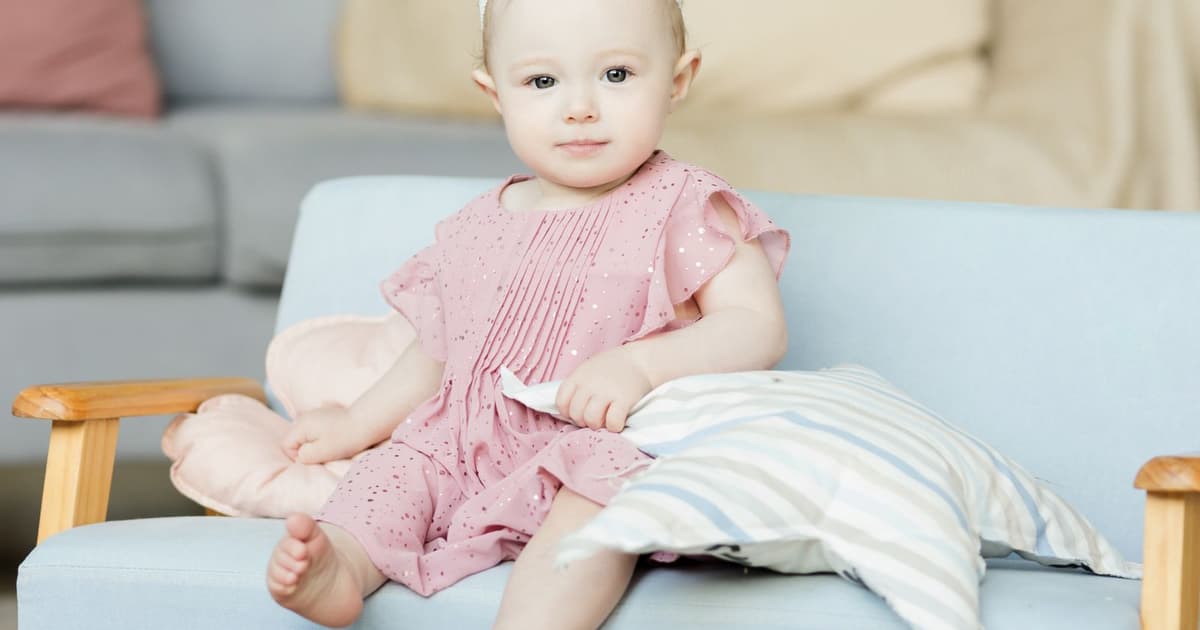 Bebis som sitter själv i en soffa