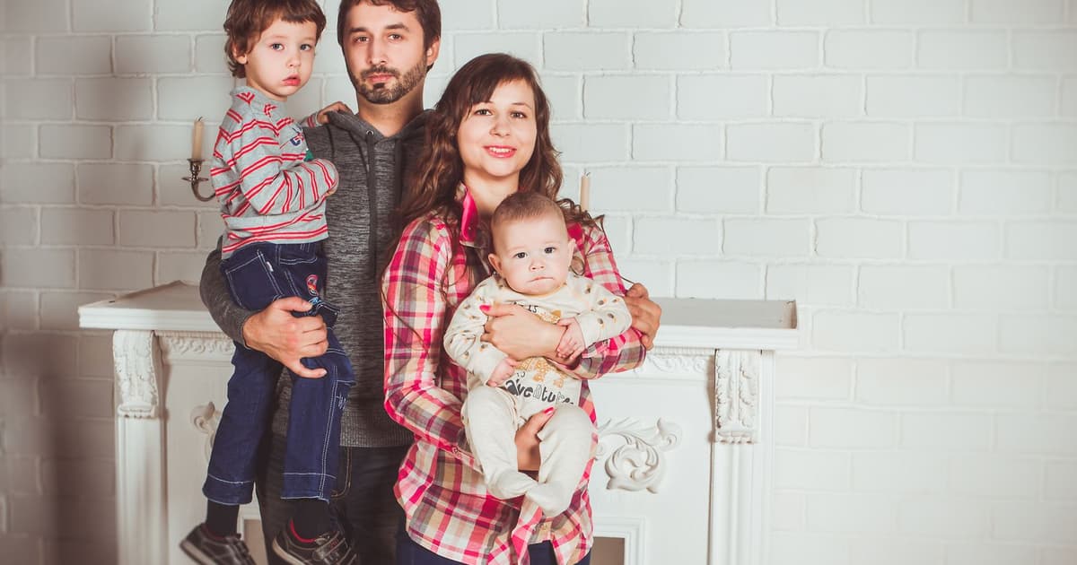 En familj med två barn tillsammans hemma i vardagsrummet